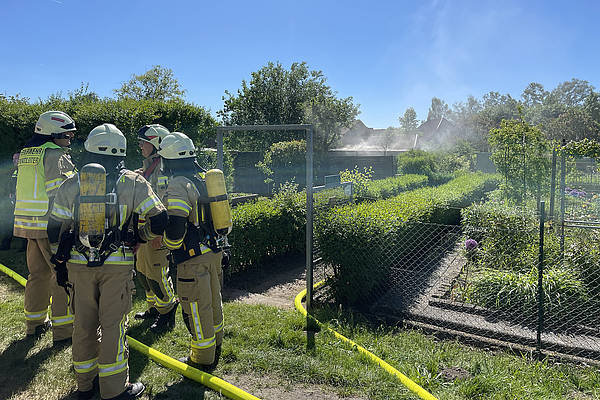 Feuerwehrkräfte löschen brennende Gartenlaube in Kleingartenkolonie